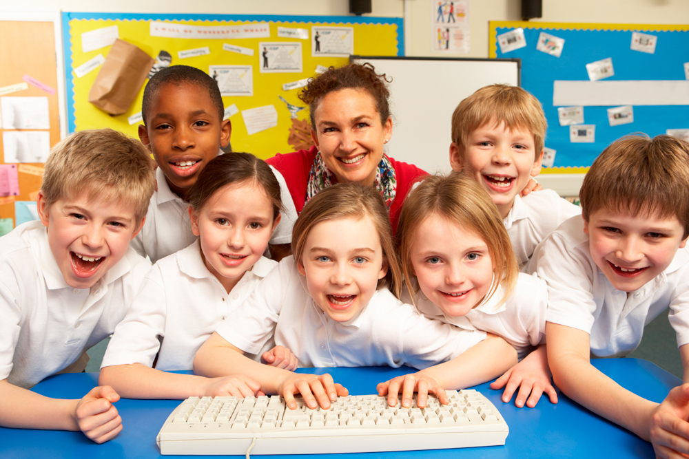 A group of children in front of a computer keyboard