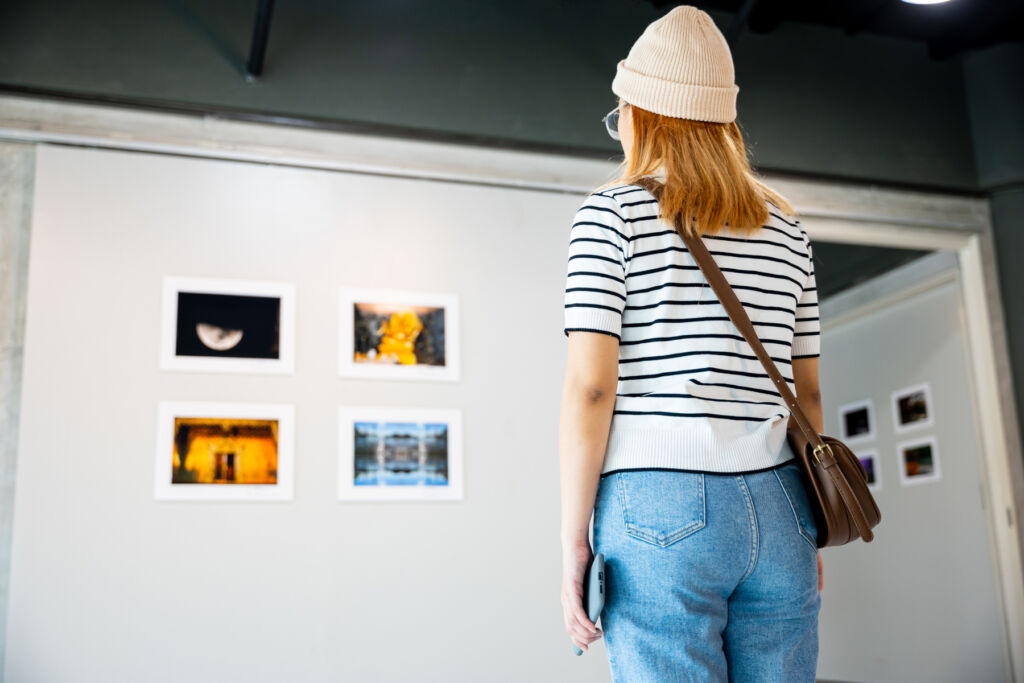 A young woman admiring art hung on a gallery wall