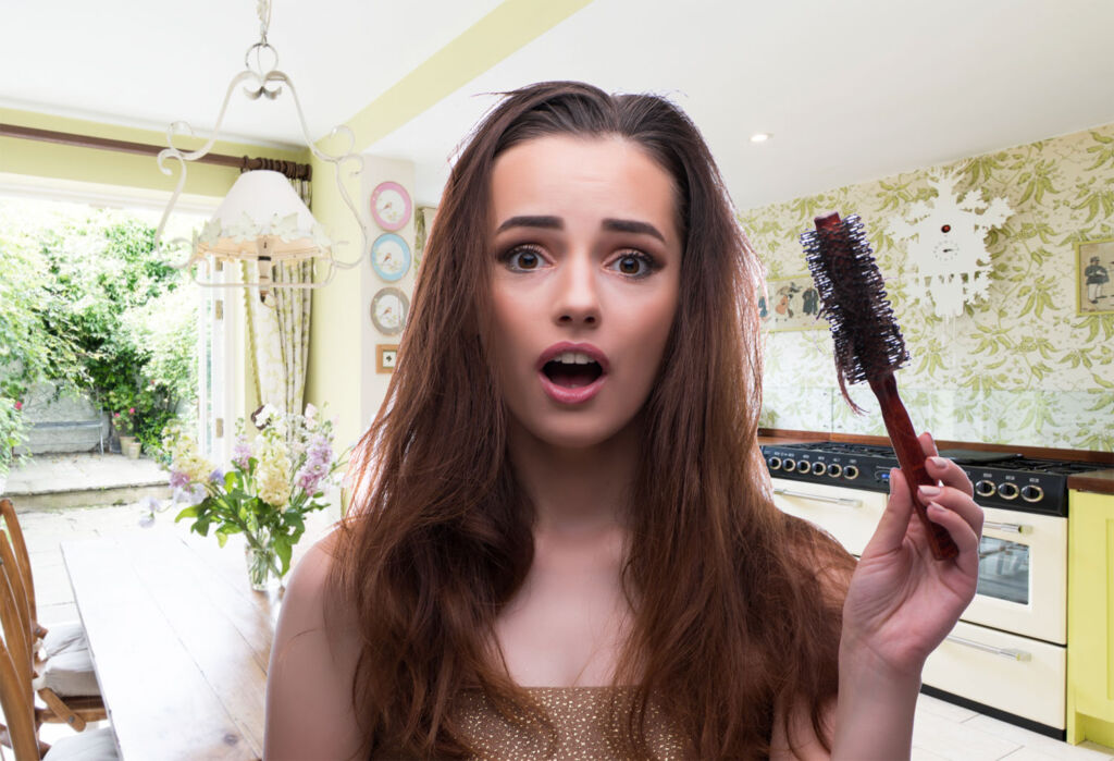 A young woman discovering excessive hair loss after brushing
