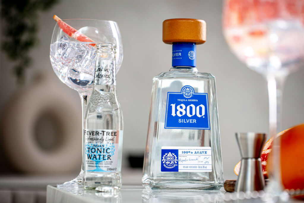 Bottle of 1800® Tequila with some filled glasses