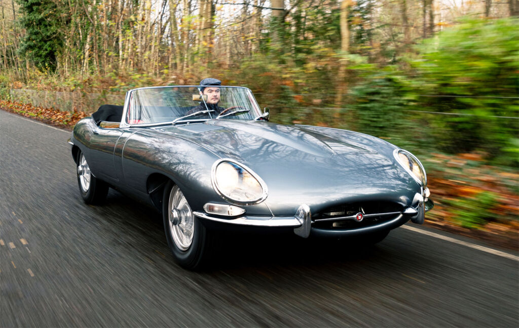 Driver enjoying a jaunt out in a E-Type Jaguar along country roads
