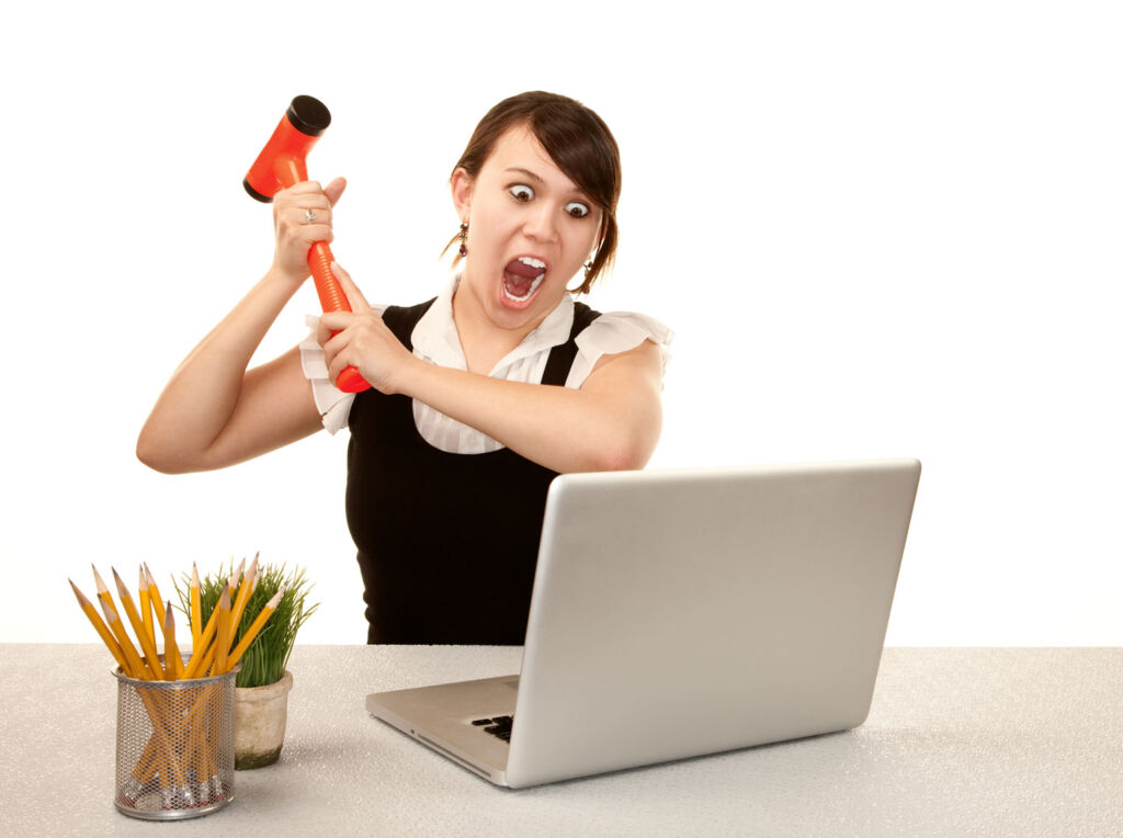 Young woman ready to smash her computer with a hammer due to feeling societal pressure