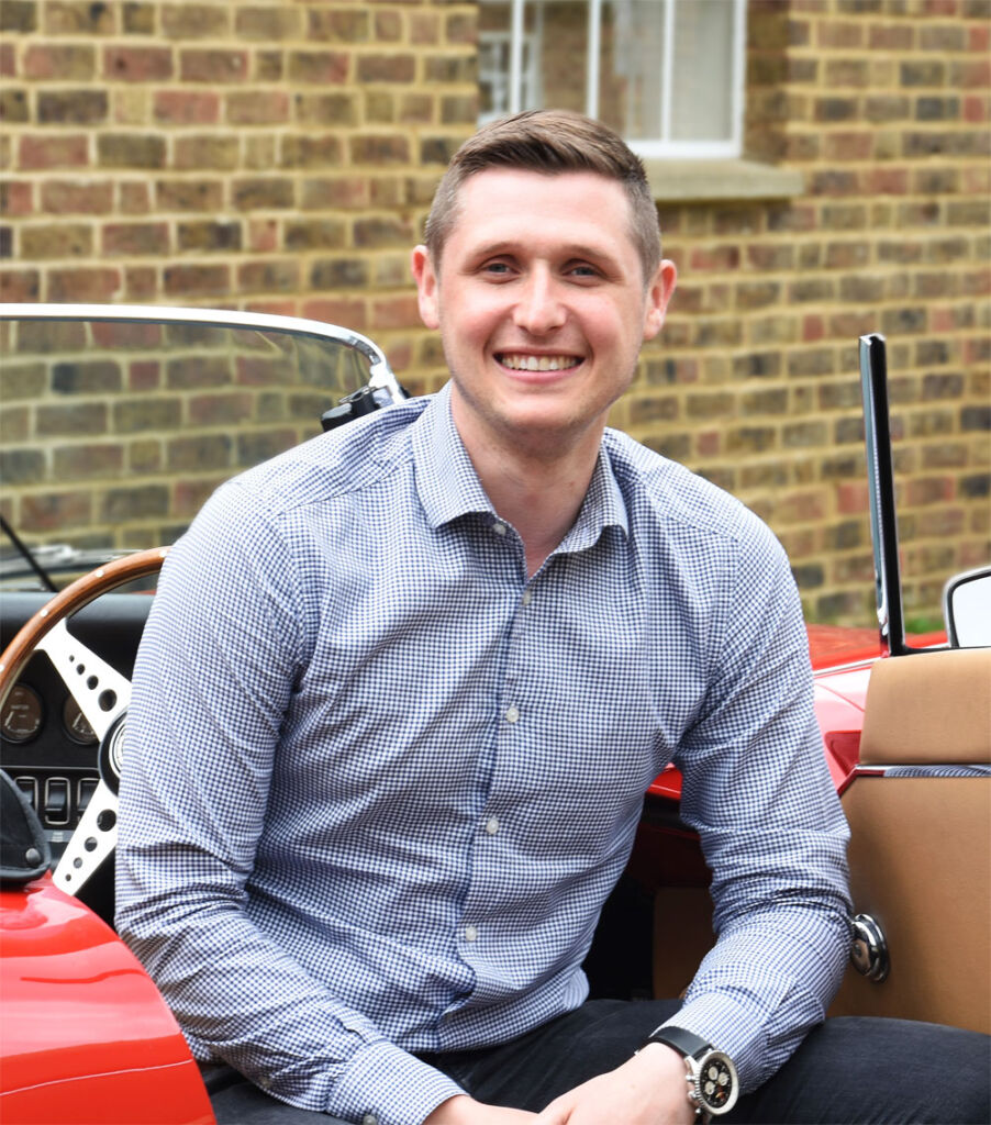 Marcus Holland the Managing Director and owner of E-Type UK sat in a classic E-Type Jaguar