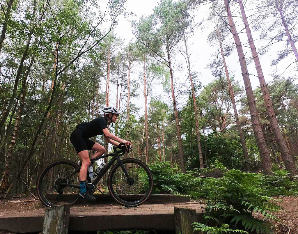 Natalie Creswick cycling through a forest