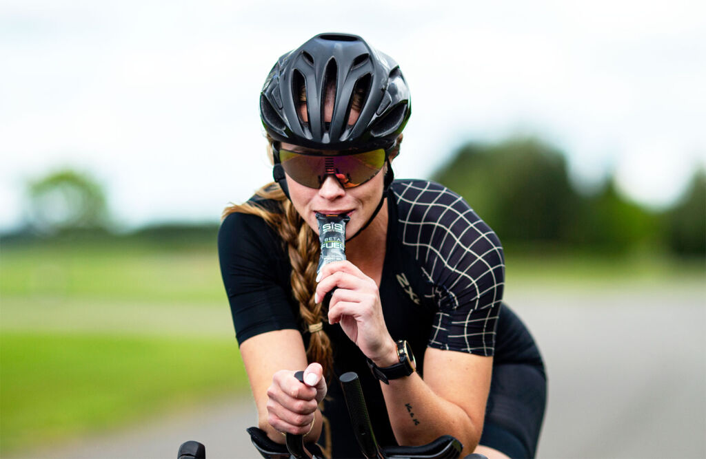 A female cyclist taking in  Science in one of Sport's New Beta Fuel bar