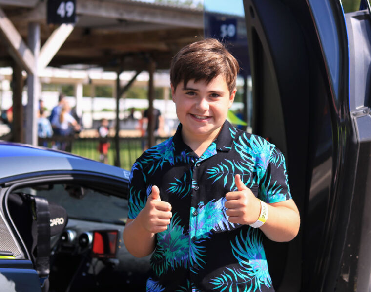 Two thumbs up from a young man at the Children’s Trust Supercar Event at Goodwood