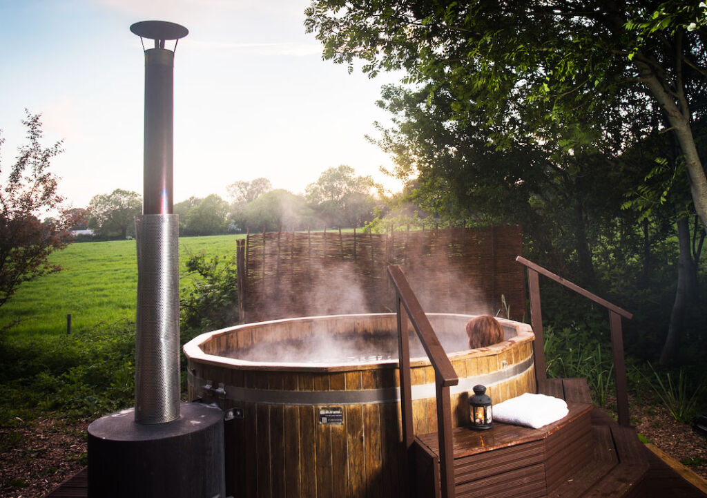 Someone enjoying the wood fired hot tub in the great outdoors
