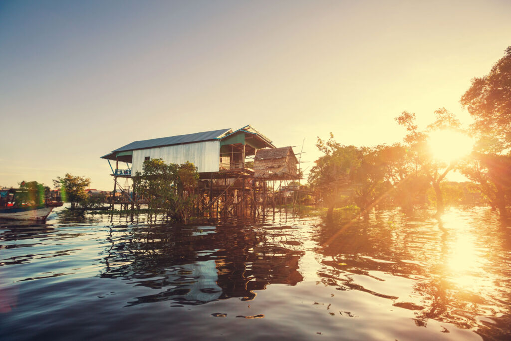 A house on stilts in the water in Cambodia at sunset