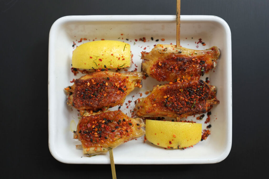 A plate of Chicken Wing Yakitori on skewers