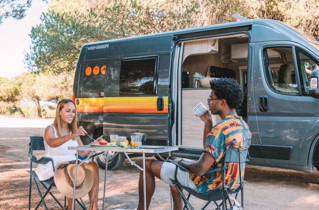 Couple enjoying some refreshments by an Indie Campers Nomad Camper van