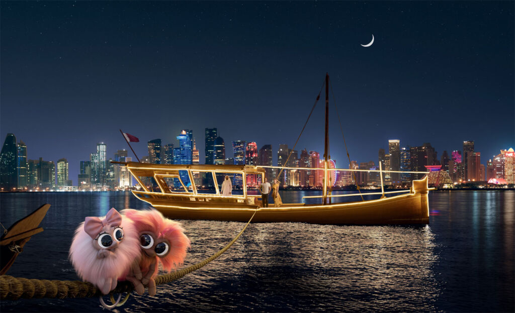 Two of the pink fluffy characters admiring Dhow Boats at night