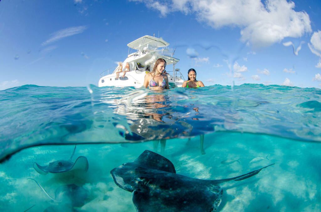 Young ladies meeting stingrays in the Cayman Islands seas