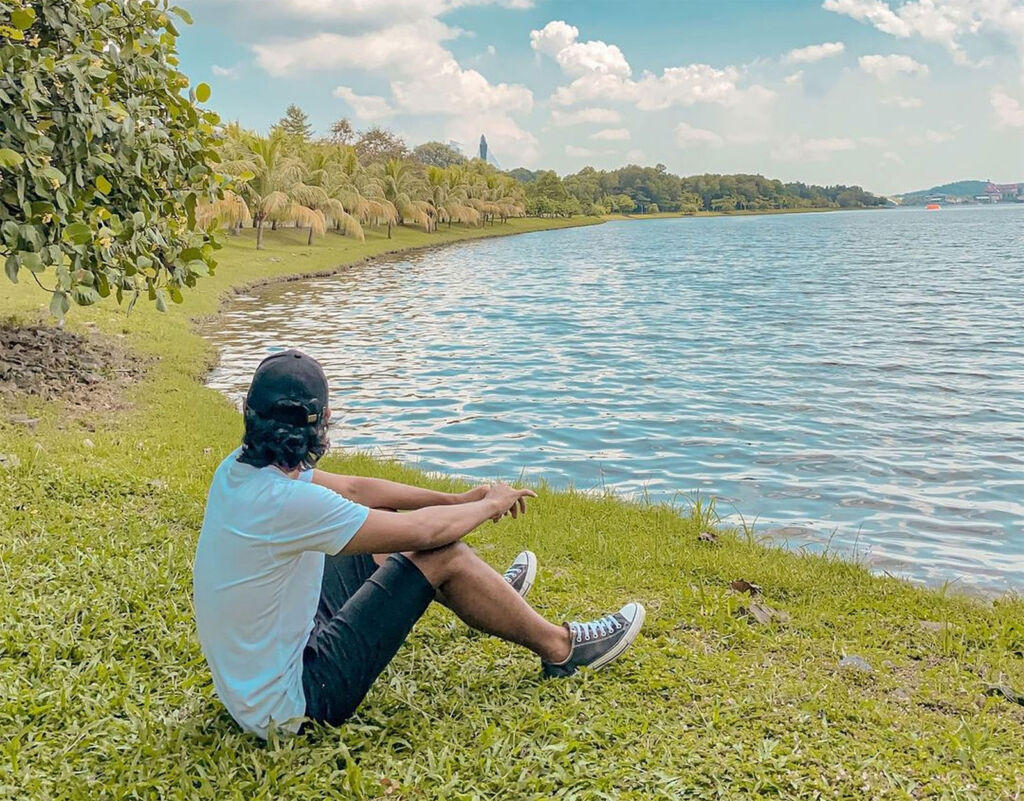 A young man sitting by the lake at Perdana Lake