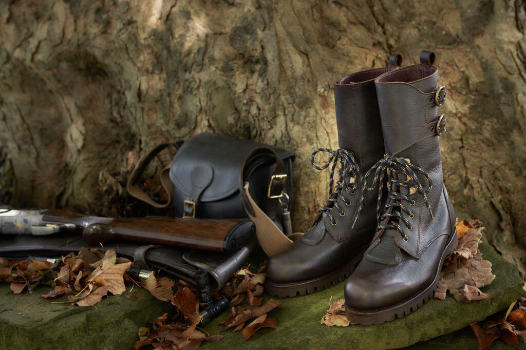 The Field & Moor leather Osprey Boots next to a tree