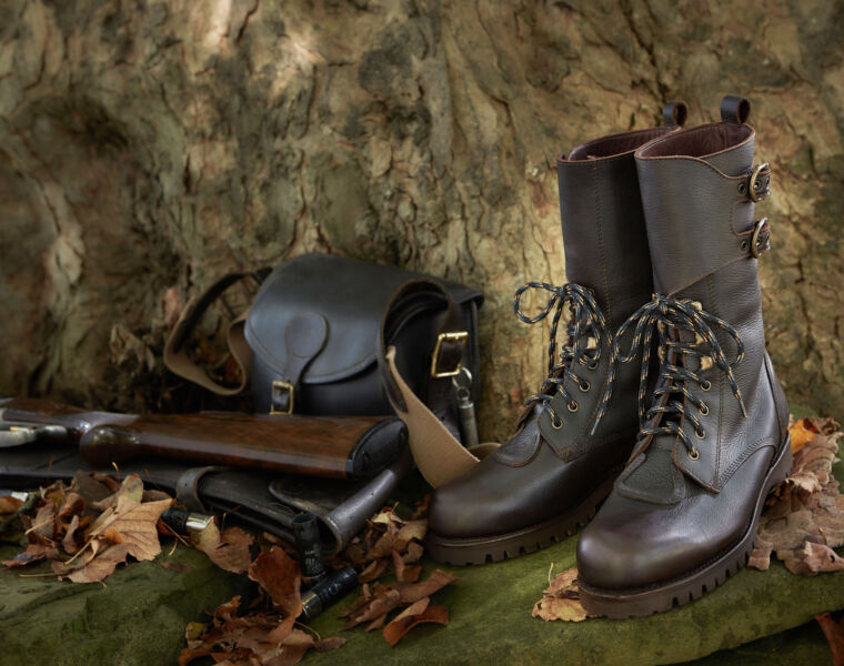 The Field & Moor leather Osprey Boots next to a tree