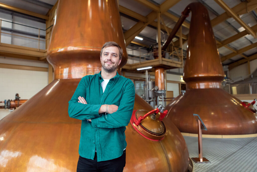 Iain standing in front of the copper stills