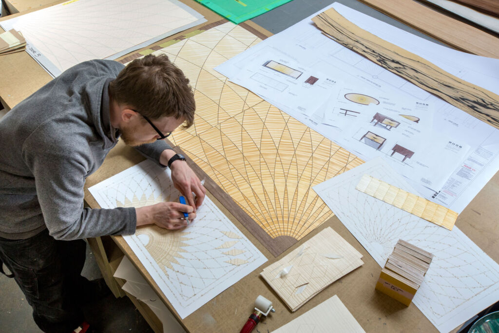 One of the designers working on a marquetry project in the workshop