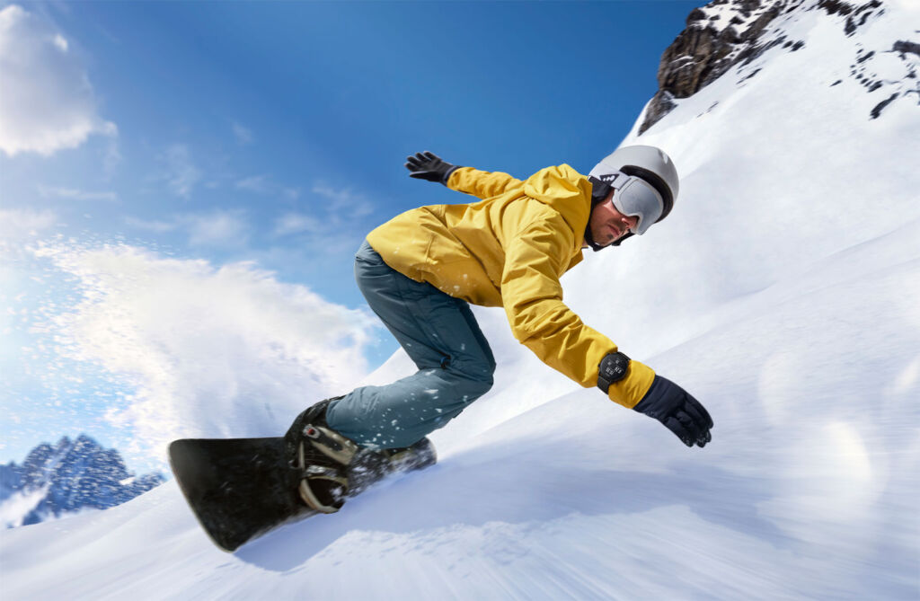 A snowboarder heading down the slopes wearing the smartwatch