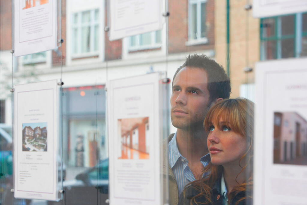 Couple looking a property in a estate agents window