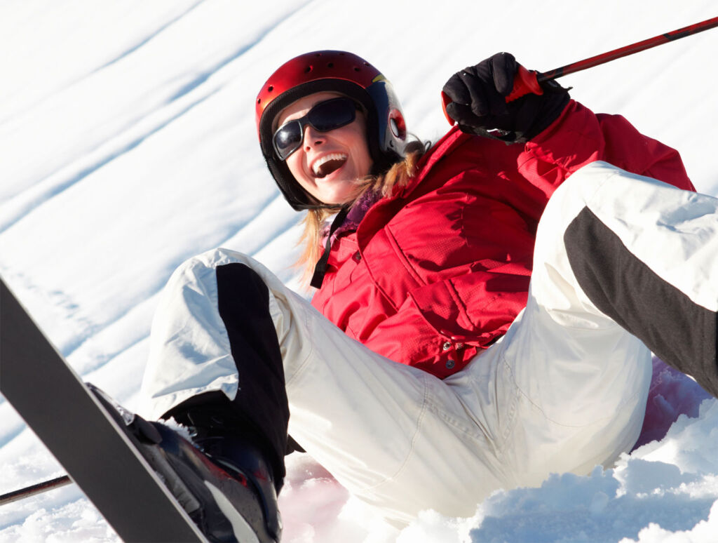 A female skier falling over on the slopes