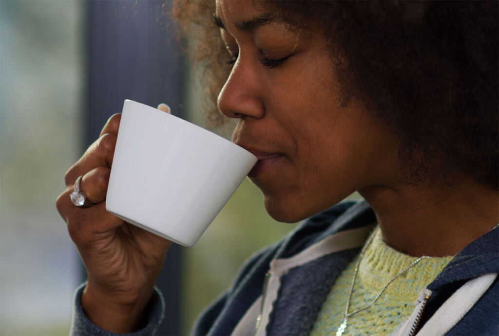 A woman drinking a cup of coffee before bedtime