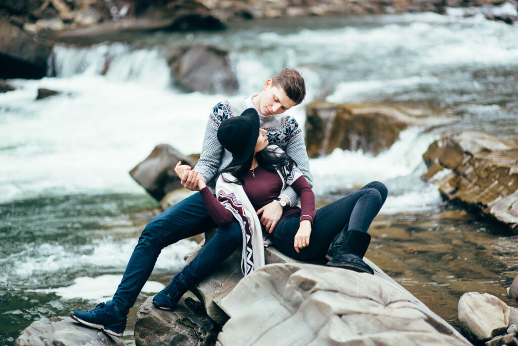 A young couple relaxing by a waterfall