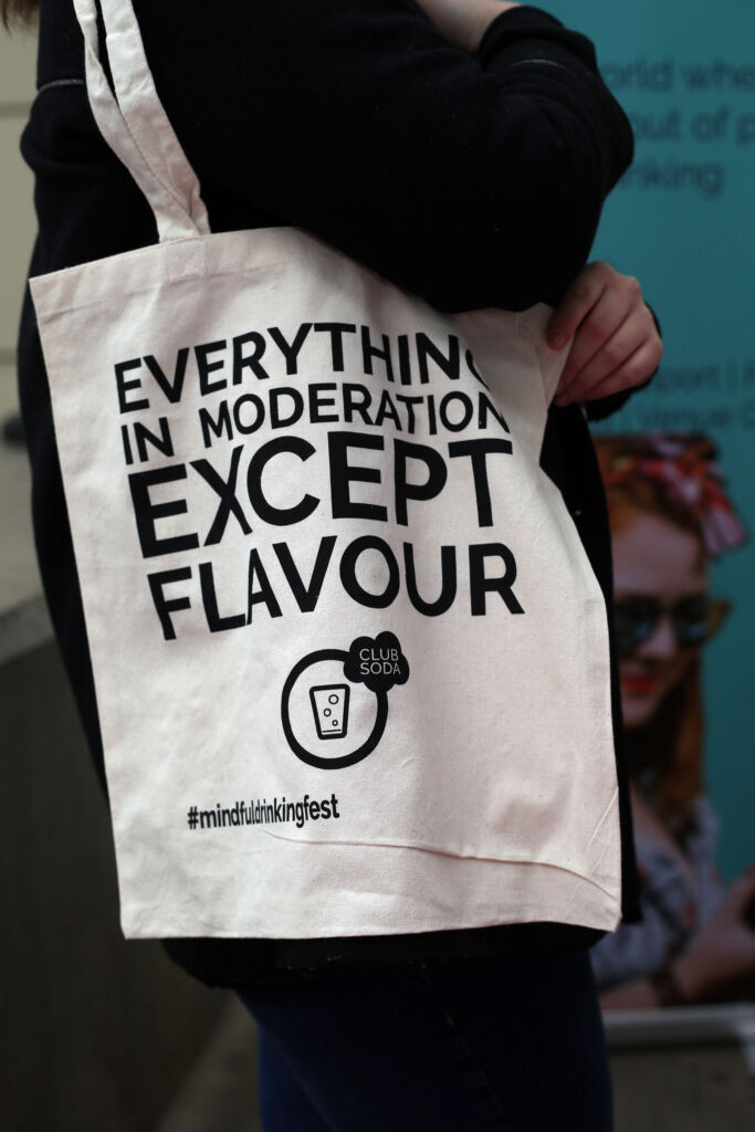 A person with a Club Soda bag stating 'Everything in moderation, Except Flavour'
