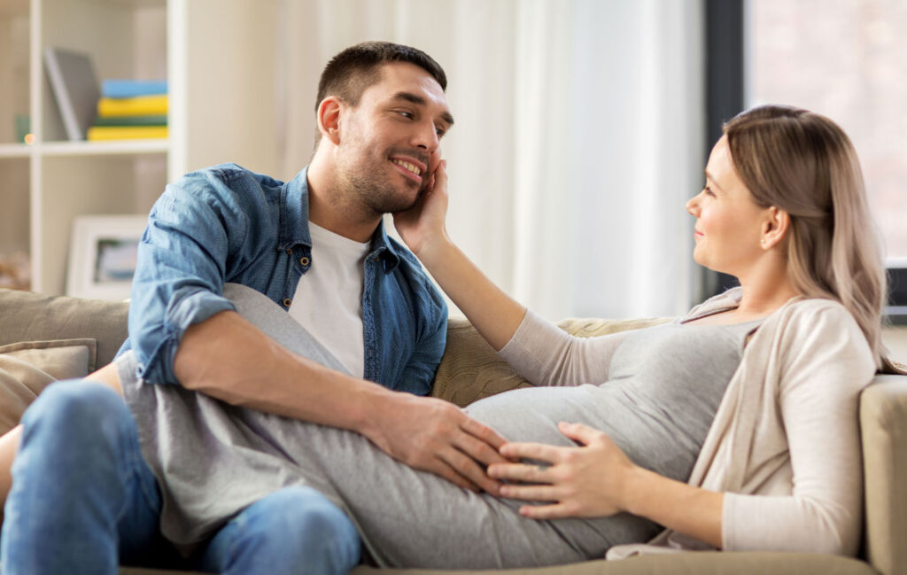 A man discussing charitable donations with his pregnant wife 