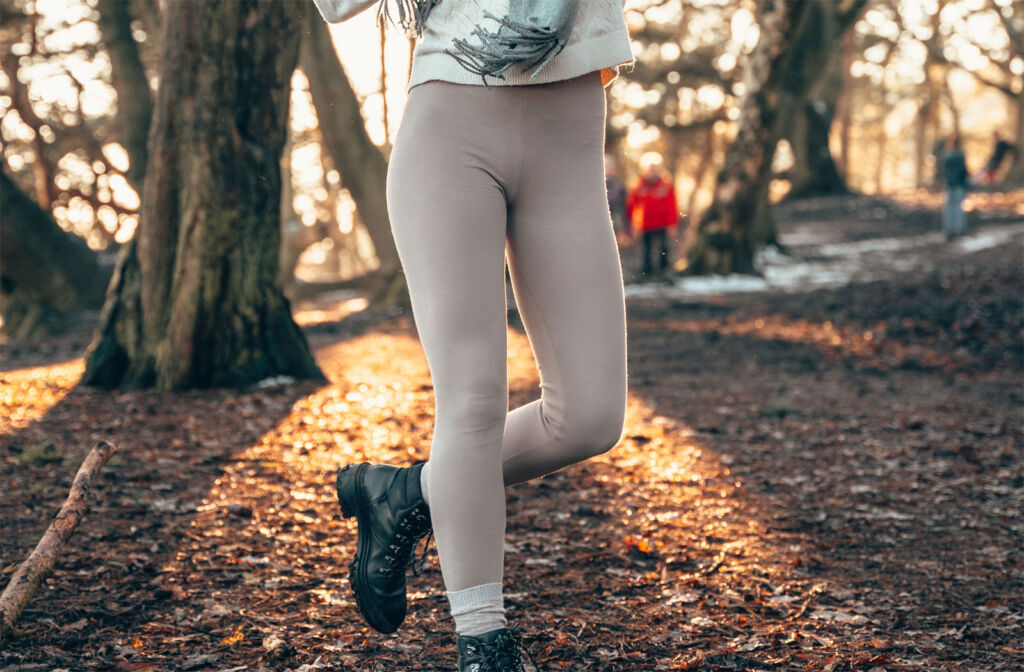 Woman wearing oatmeal coloured love leggings in a park