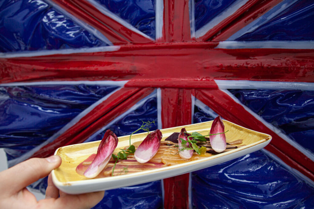 One of the dishes behind a ceramic union jack on the wall