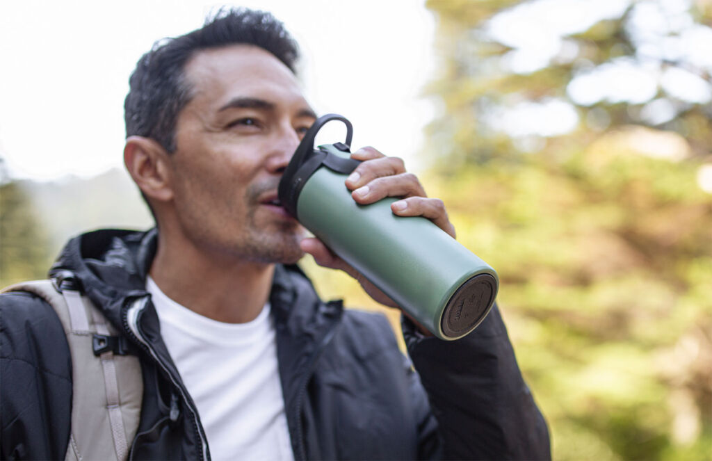A man drinking out of the CamelBak Forge Flow Travel Mug