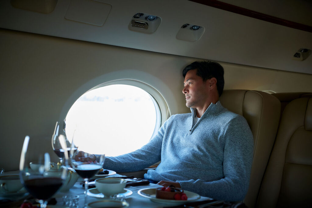 A man enjoying a flight on a private jet with Priester