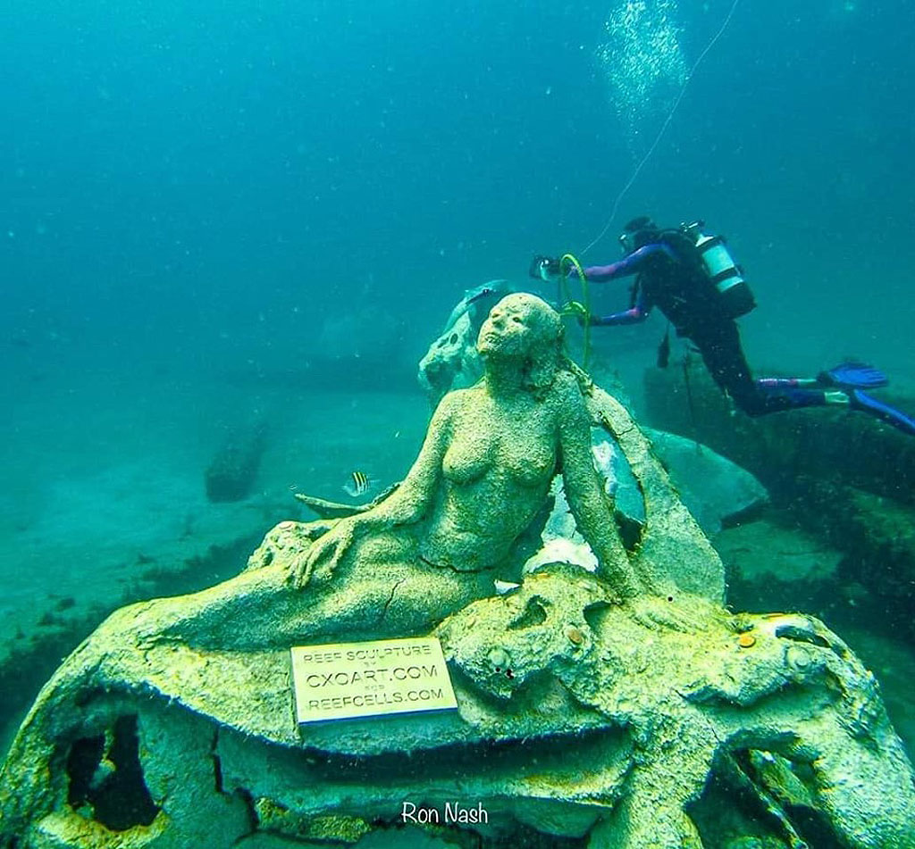 A diver taking a look at a sculpture underwater