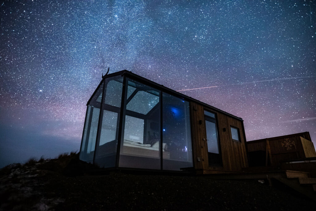 One of the Off The Map Glass cabins in Iceland at night under a star filled sky