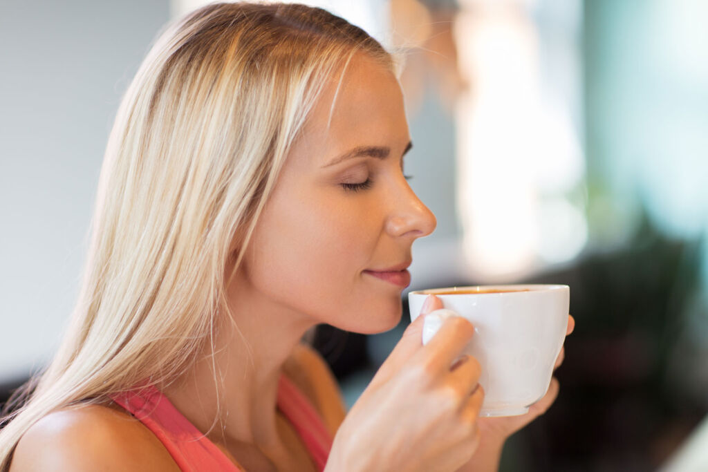 A woman drinking a fresh cup of coffee