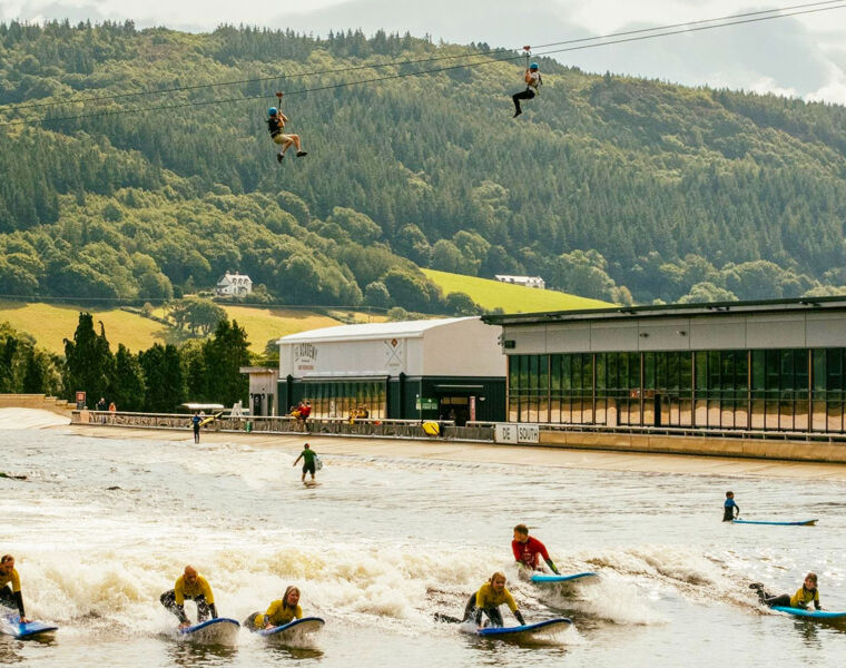 People zip-lining and surfing at the parc