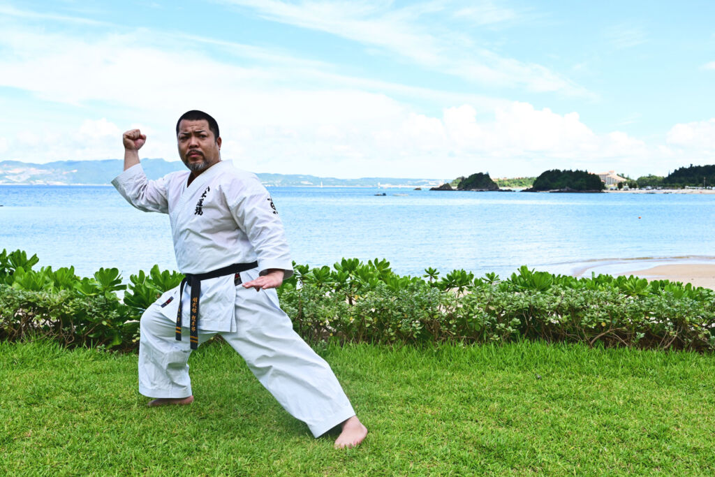 A black-belt practicing Karate moves on the beachfront