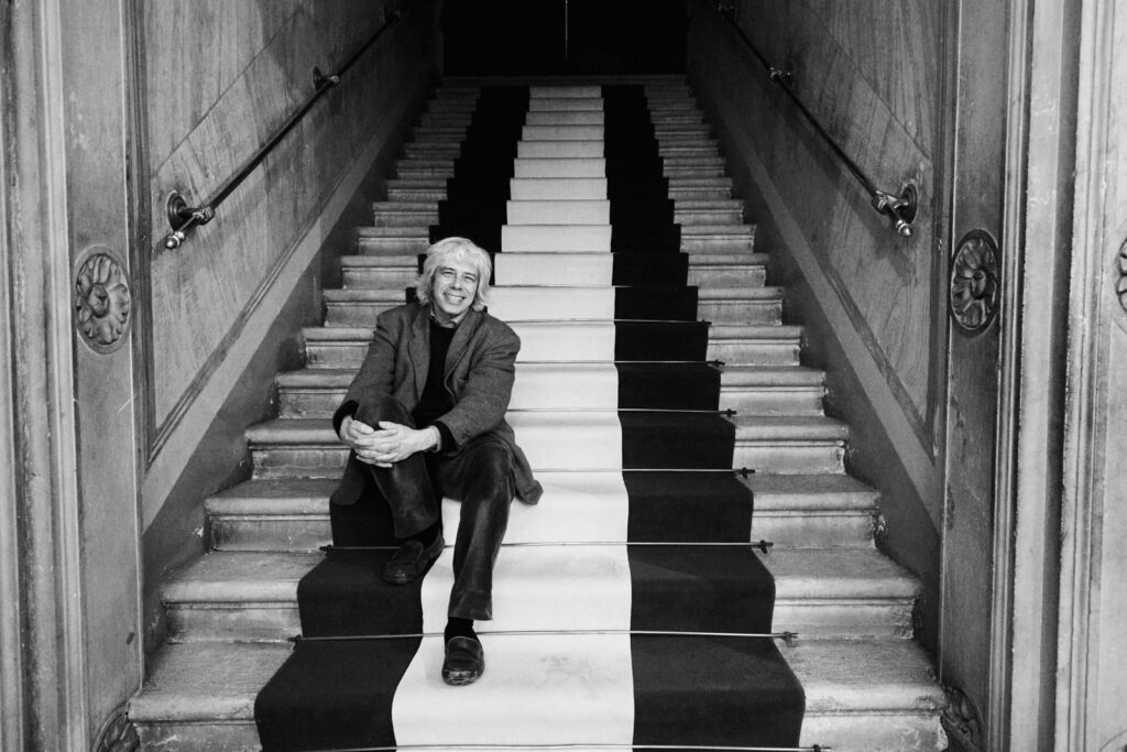 Black and white photograph of Francesco da Mosto sat on some steps