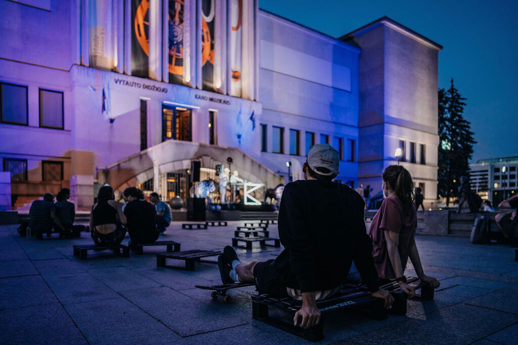 People enjoying an outdoor performance in the city at night