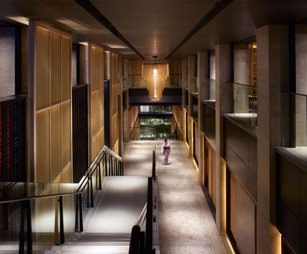 A woman walking down the lobby Atrium at the Ritz Carlton Kyoto