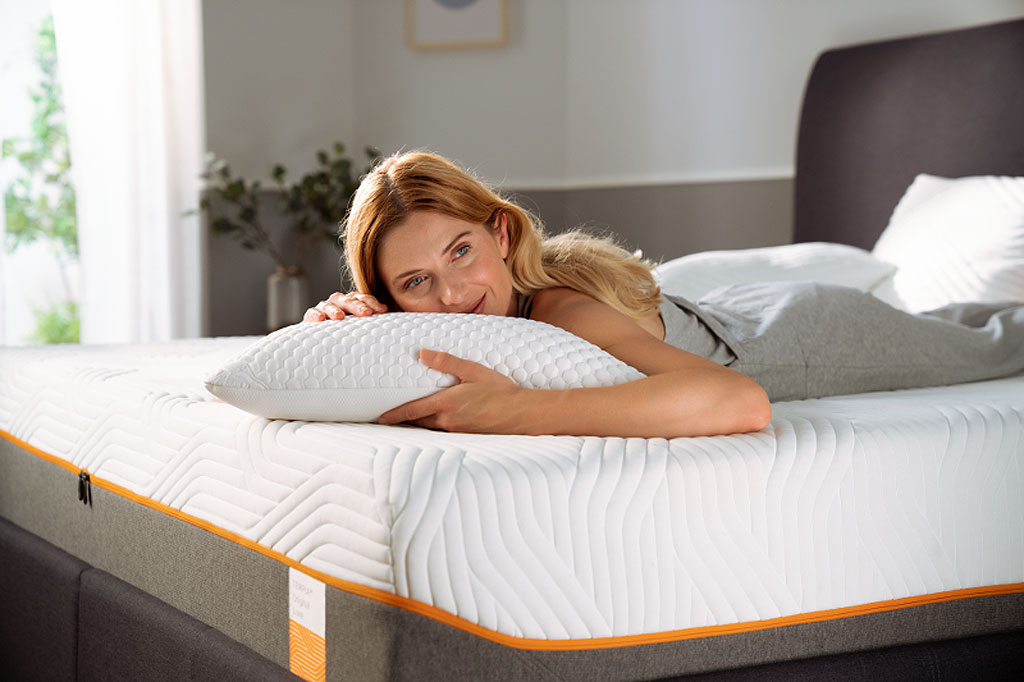 A woman relaxing with her pillow on her bed