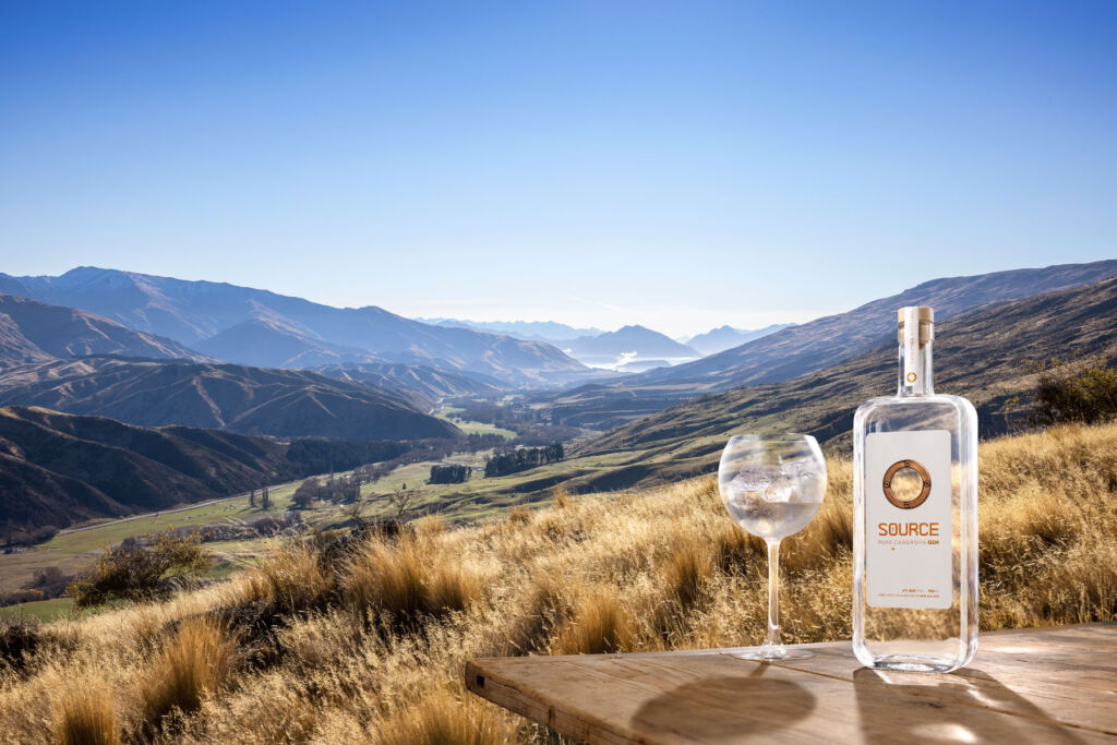 A bottle of The Source Gin with the mountains as a backdrop