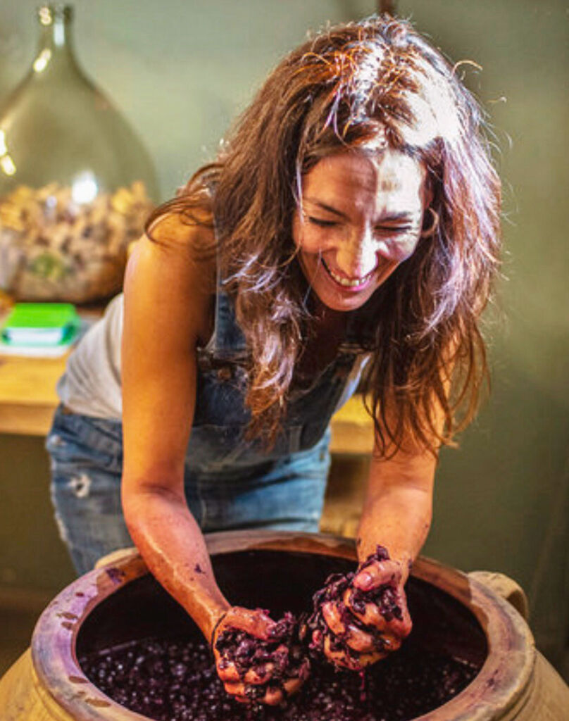 Winemaker Sara Perez crushing grapes in a barrel