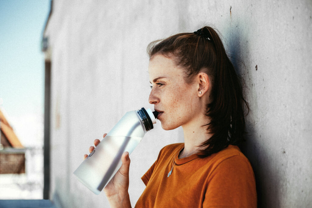 A woman drinking water out of one of the bottles