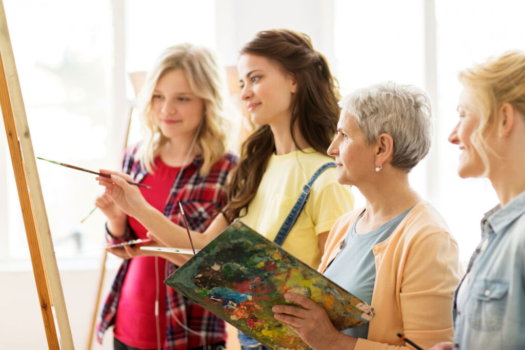 An older woman enjoying a painting class with some younger people