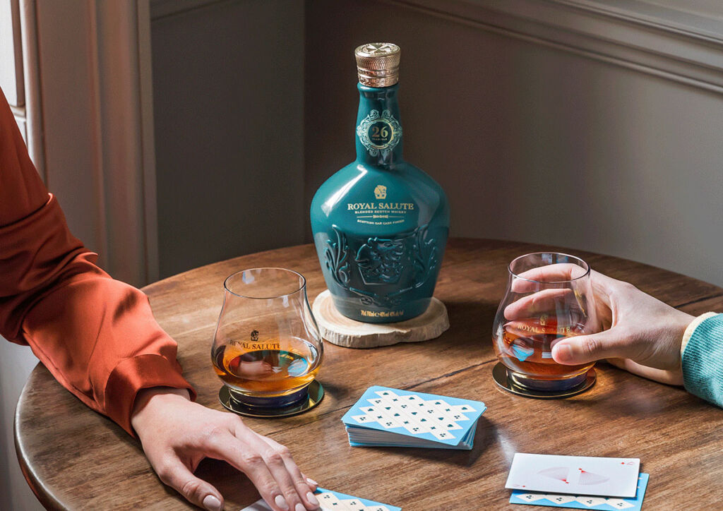 People playing cards with a flagon of the whisky on the table