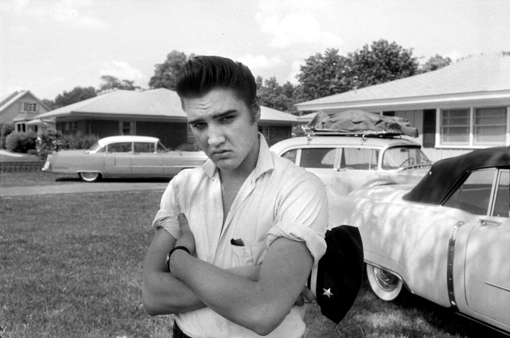 A black and white photo showing young Presley standing in a yard