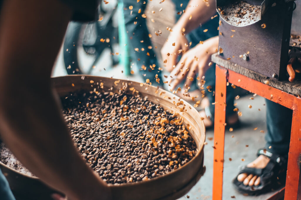 Locals filtering coffee beans in a sieve
