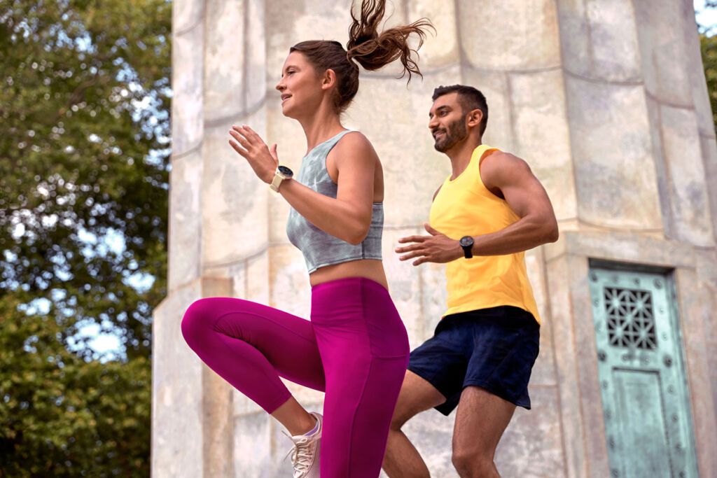 A man and a woman exercising outdoors wearing Garmin watches