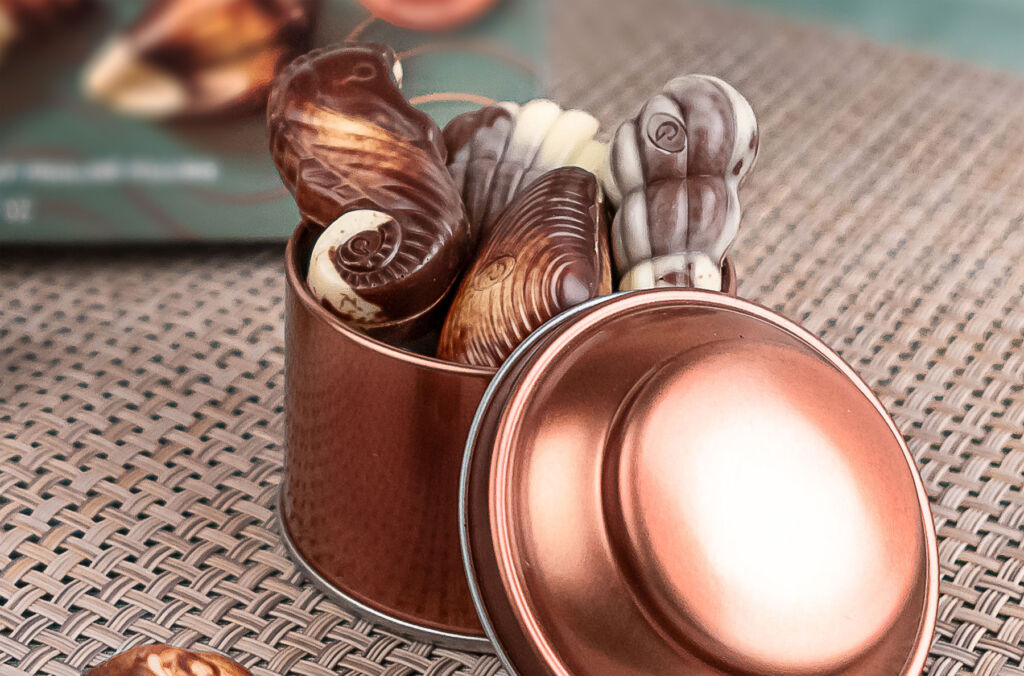 Some of the chocolates in a small copper tin